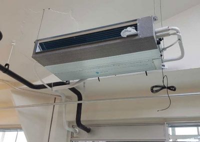 Eine Klimaanlage, die von der Decke in einem Raum hängt.