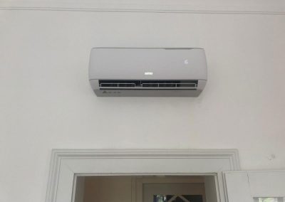 Eine weiße Klimaanlage, die an der Seite einer Wand montiert ist.