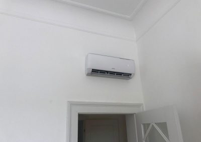 Eine weiße Klimaanlage, die an der Wand eines Raumes montiert ist.