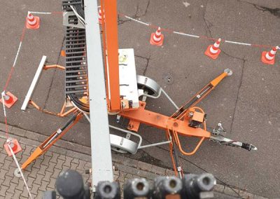 Ein Kran, der auf einem Bürgersteig neben einem Gebäude steht. Installation einer Klimaanlage von klimaalarm24 aus Karlsruhe