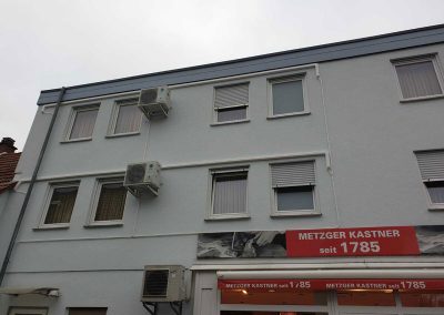 ein Altbau mit einem roten Schild davor. Am Gebäude sind Klimaanlagen von klimaalarm24.de installiert.