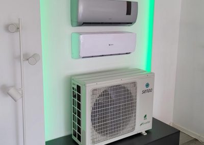 eine weiße Klimaanlage, die auf einem schwarzen Ständer steht.